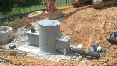 domed top fiberglass Packaged Metering Manhole being installed on a site poured concrete slab