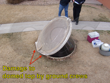 Too shallow Tracom domed top packaged metering manhole. Damage around the top and at the hinge by ground crews indicated.