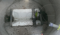 Trapezoidal flume grouted into a concrete manhole